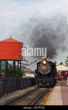 Treno a vapore antico, in arrivo alla stazione, serbatoio d'acqua rosso, nube di vapore nero, giro turistico, locomotiva n. 90, trasporto, Strasburg Railroad, Lancast Foto Stock