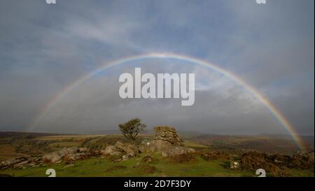 Dartmoor National Park, Devon, Regno Unito. 22 ottobre 2020. Regno Unito Meteo: Un arcobaleno pieno appare nel cielo sopra l'iconico Holwell Tor su Dartmoor dopo forti docce a pioggia e incantesimi di sole che portano una sensazione distintamente autunnale al giorno. Credit: Celia McMahon/Alamy Live News Foto Stock