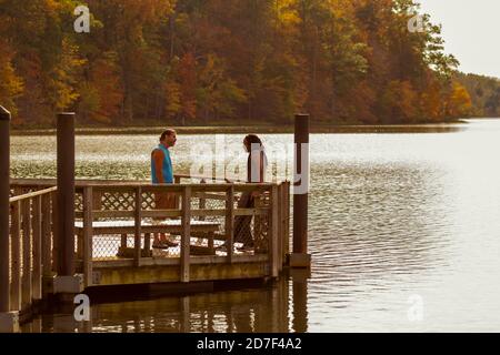 Boyds, MD, USA 10/20/2020: Un giovane afroamericano e il suo amico caucasico stanno facendo una discussione accesa mentre si trovano sul molo di legno da li Foto Stock