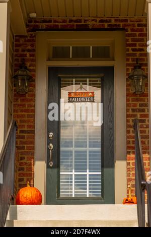 Montgomery County, MD, USA 10/21/2020: Porta d'ingresso di una casa con decorazioni semplici ma eleganti. Ci è un avviso felice di Halloween sulla th Foto Stock