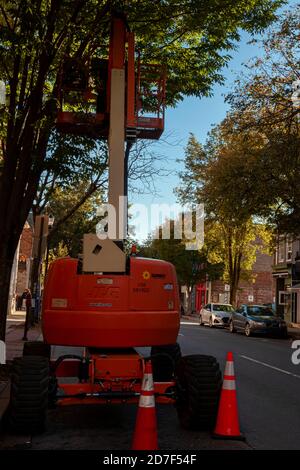 Frederick, MD, USA 10/13/2020: Immagine ravvicinata di un sollevatore telescopico idraulico JLG, noto anche come picker di ciliegio, parcheggiato sul lato di una strada sotto una tre Foto Stock