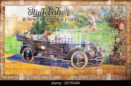Vecchia pubblicità in azulejos sul muro di Siviglia. Pubblicità dipinta di una vecchia macchina Studebaker. Foto Stock