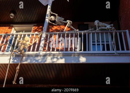 Frederick, MD, USA 10/13/2020: Una decorazione halloween molto creativa al secondo piano balcone di una casa. Scheletri spaventosi stanno arrampicandosi per rompere e. Foto Stock
