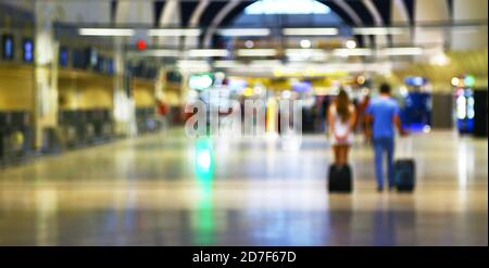 Giovani con bagagli a piedi in aeroporto Foto Stock