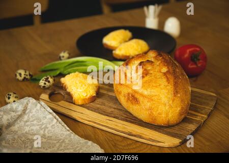 Panino sano con baguette integrale di frumento, uova fritte, formaggio, pomodori su tavola di legno Foto Stock