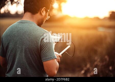 Drone controller uomo che opera drone volare Foto Stock