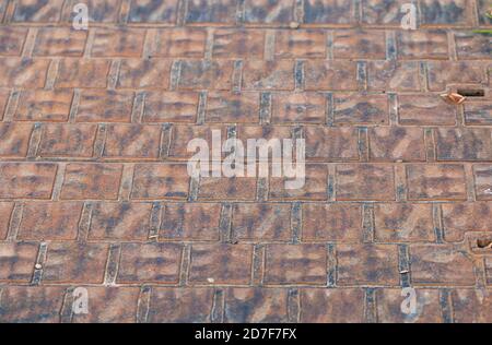 Asfalto, lastre per pavimentazione. Sfondo astratto dall'imitazione di ciottoli, tono marrone. Messa a fuoco selettiva. Foto Stock