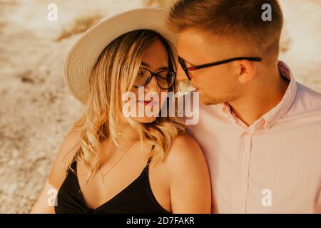 l'uomo e la donna in cappello sono seduti su una grande pietra roccia Foto Stock