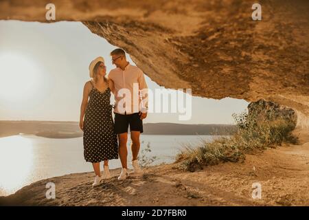 l'uomo e la donna in cappello camminano lungo le rocce sopra il scogliera