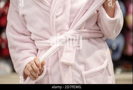 Una giovane donna cerca un accappatoio in un negozio . Primo piano. Foto Stock