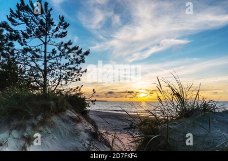 Tramonto sul mare. Riflesso della luce solare nelle onde del mare. Cielo rosso nei raggi del tramonto. Foto Stock