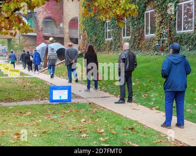 Oak Park, Illinois, Stati Uniti. 22 ottobre 2020. I primi elettori sopportano il clima umido e aspettano fino ad un'ora e mezza per votare oggi nella sala del villaggio in questo sobborgo occidentale di Chicago. Foto Stock
