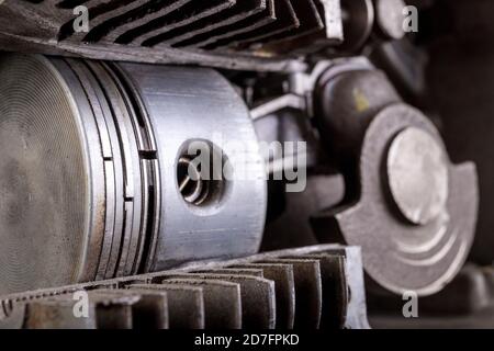 Un piccolo motore a combustione interna mostrato nella sezione. Vista del pistone e delle fasce elastiche nel motore. Sfondo scuro. Foto Stock