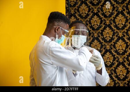 persone mediche africane in camici da laboratorio che effettuano uno studio e test Foto Stock