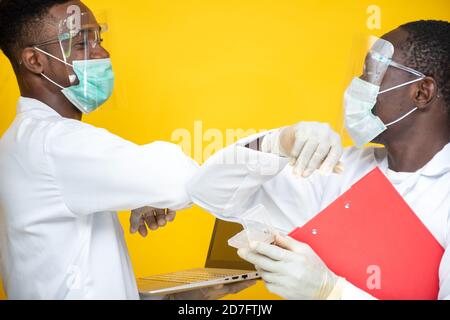 due scienziati di laboratorio neri salutano toccando i loro gomiti Foto Stock