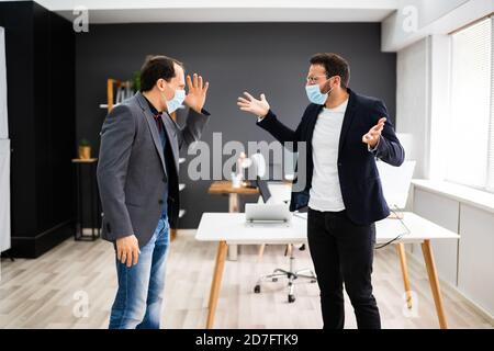 Arrabbiato Bully combattendo sul lavoro. Luogo di lavoro dispute in maschera facciale Foto Stock