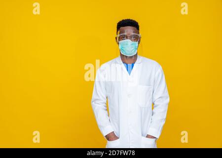 ritratto di un personale medico africano che indossa un camice da laboratorio, una maschera facciale e uno scudo Foto Stock