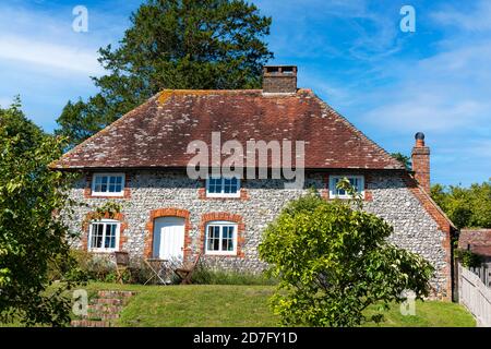 Un cottage in pietra focaia Sussex tradizionale nel villaggio di East Dean ai piedi delle Downs Sud nel Sussex Ovest. Foto Stock