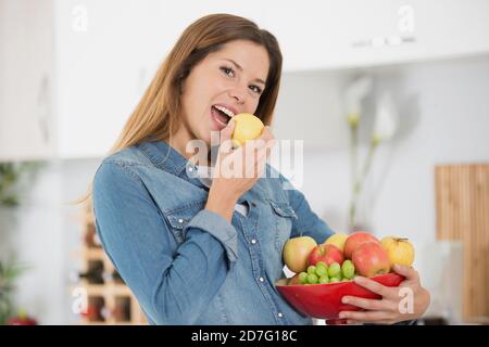 ritratto di una bella ragazza che mordicchiava una mela Foto Stock