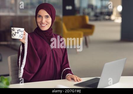 Giovani arabi business donna indossa hijab,lavorando nel suo ufficio di avvio. La diversità, multirazziale concept Foto Stock