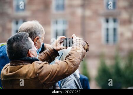 Strasburgo, Francia - Ott19, 2020: Uomo che prende il phot di Place Kleber per rendere omaggio all'insegnante di storia Samuel Paty, decapitato su Ott16 dopo aver mostrato le caricature del profeta Muhammad in classe Foto Stock