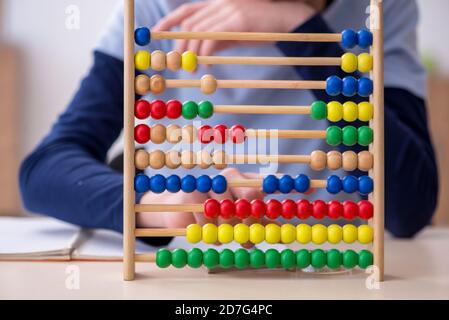 Ragazzo con abaco che studia matematica a casa Foto Stock