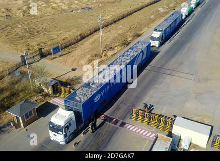 (201023) -- PECHINO, 23 ottobre 2020 (Xinhua) -- Foto aerea scattata il 22 ottobre 2020 mostra camion caricati con pecore donate dalla Mongolia passando dal porto di Erenhot a Erenhot, regione autonoma della Mongolia interna della Cina del nord. Più di una dozzina di camion caricati con 4,000 pecore dalla Mongolia sono arrivati nella città di confine Cina-Mongolia di Erenhot, regione autonoma della Mongolia interna, giovedì. Questo è stato il primo lotto di 30,000 pecore donate dalla Mongolia a sostegno della lotta contro l'epidemia cinese COVID-19. Secondo un accordo bilaterale, le pecore vengono trasportate a Erenhot in lotti, dove vengono macellate Foto Stock