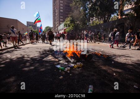 SANTIAGO, CILE-18 OTTOBRE 2020 - i dimostranti camminano vicino ad una barricata durante una protesta a Plaza Dignidad (ex Plaza Italia) a Santiago, uno y Foto Stock