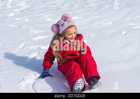 Bambina che cavalca sugli scivoli di neve in inverno. Natale e Felice Anno Nuovo. Foto Stock