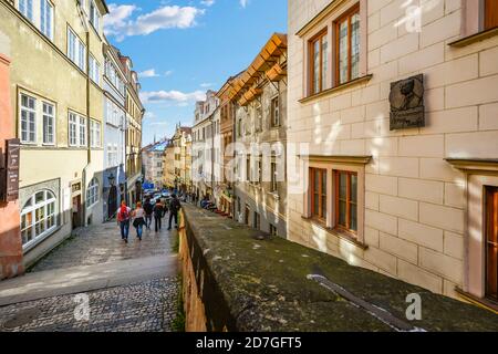 I turisti si dirigono lungo la lunga scalinata attraverso un quartiere residenziale dal Castello di Praga attraverso la Città bassa verso la Città Vecchia di Praga, in Czechia Foto Stock