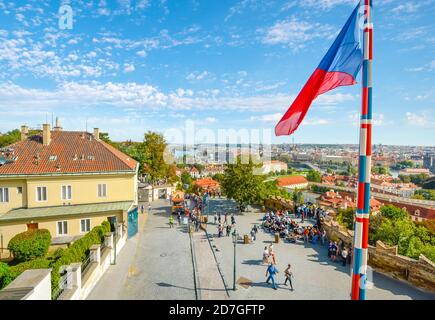 Una vista dal Castello di Praga che mostra il centro di Praga e il fiume Moldava in lontananza con la bandiera ceca che vola in primo piano Foto Stock