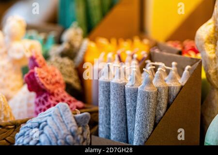 Diversi colori e forme di candele sul mercato di Natale, primo piano, messa a fuoco morbida Foto Stock