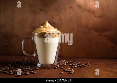 caffè di algone freddo in bicchieri trasparenti su fondo di legno scuro. schiuma di zucchero e caffè istantaneo viene montata con un miscelatore sul latte freddo. Coreano e. Foto Stock
