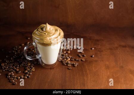 caffè di algone freddo in bicchieri trasparenti su fondo di legno scuro. schiuma di zucchero e caffè istantaneo viene montata con un miscelatore sul latte freddo. Coreano e. Foto Stock