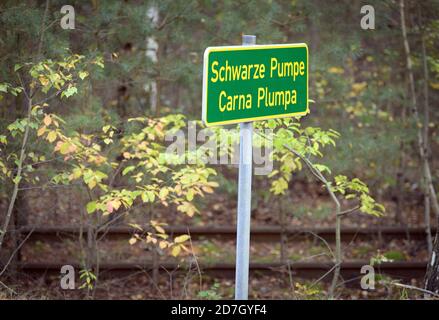 Spreetal, Germania. 19 Ott 2020. Un cartello 'Schwarze Pumpe' in lingua tedesca e sorbiana si trova sul lato della strada di fronte a piste ferroviarie arrugginite. Credit: Soeren Stache/dpa-Zentralbild/ZB/dpa/Alamy Live News Foto Stock