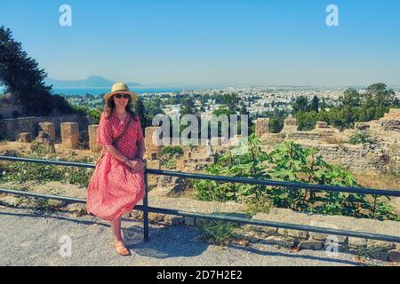 Una giovane donna vicino alle rovine della città di Cartagine distrutta da Roma. Turistico presso gli edifici cartaginesi dell'antica Tunisia, Africa Foto Stock