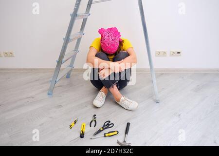 Una donna grida a causa della complessità e dei problemi con riparare la casa con le proprie mani Foto Stock