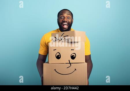 Happy man ha molti pacchetti ricevuti. Sfondo ciano Foto Stock