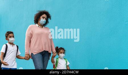 Madre con figlio e figlia indossare maschera di protezione viso andare Torna a scuola durante la pandemia del virus della corona - Sanità e. concetto di istruzione Foto Stock
