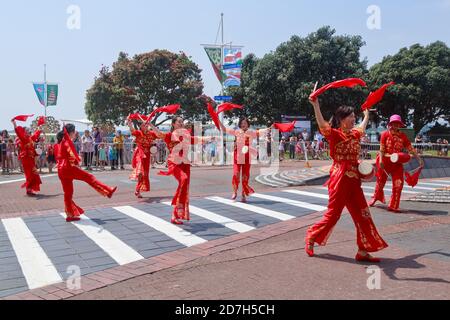 Donne cinesi con abiti tradizionali e timpani in vita, che eseguono una danza sciarpa per le strade. Fotografato in una parata a Tauranga, Nuova Zelanda Foto Stock