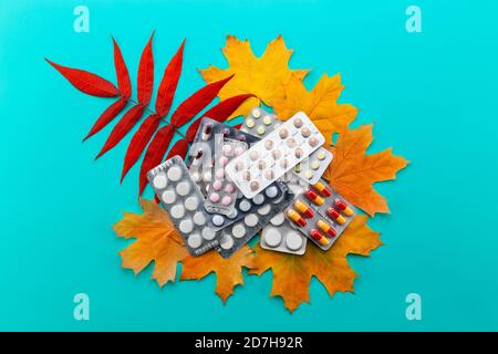 Pillole, capsule e blister confezioni di compresse su foglie di acero giallo e rosso. Concetto di farmacia, antidepressivi, vitamine per l'immunità in autunno influenza Foto Stock