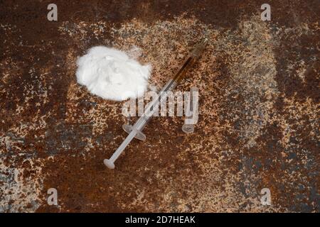 Siringa e farmaci su sfondo sporco e arrugginito. Siringa per iniezione. Dipendenza Foto Stock