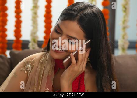 Bella ragazza sorridente mentre parla al suo telefono Foto Stock