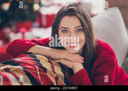 Ritratto di bella ragazza sedete comodo divano sguardo dentro telecamera che riparte il sorriso all'interno della casa con x-mas celebrazione Foto Stock