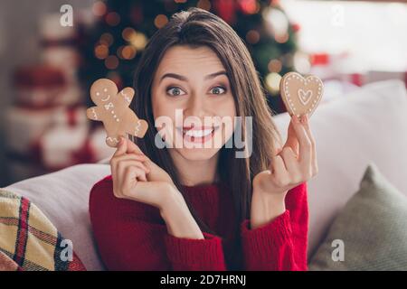 Ritratto di ragazza positiva tenere due x-mas delizioso cuore uomo formare i biscotti allo zenzero all'interno dell'hotel Foto Stock