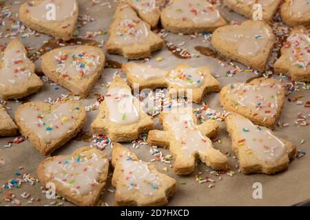 Cottura di Natale: Biscotti shortcrosta con glassa di zucchero su carta da forno Foto Stock