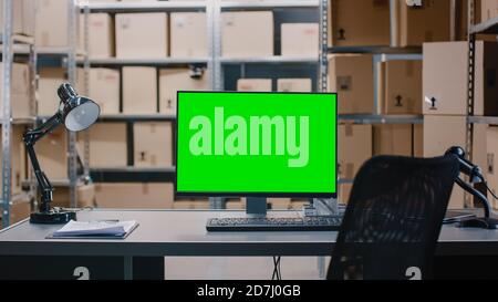 Immagine di un warehouse Inventory Manager Desk e di un personal computer con foglio di calcolo aperto. Negli scaffali di sfondo pieni di scatole di cartone Foto Stock