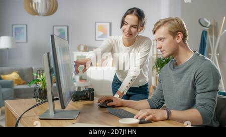 I redattori professionisti maschili e femminili parlano mentre lavorano nel software dell'applicazione di editing fotografico su un personal computer. Editor di foto che ritoccano le foto di a. Foto Stock