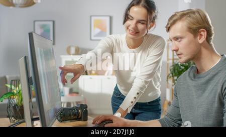 I redattori professionisti maschili e femminili parlano mentre lavorano nel software dell'applicazione di editing fotografico su un personal computer. Editor di foto che ritoccano le foto di a. Foto Stock