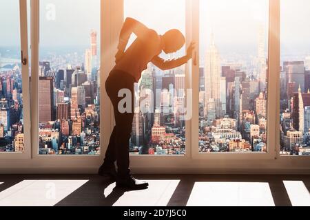 Giovane imprenditore che soffrono di Backpain In ufficio moderno Foto Stock